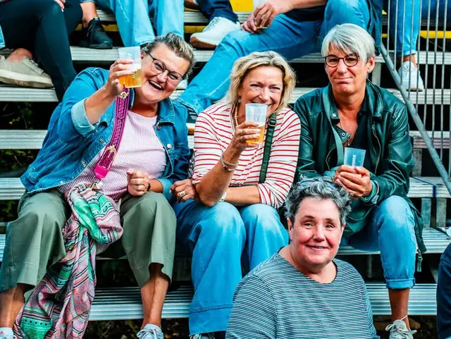 Frauengruppe sitzt entspannt auf den Treppenstufen beim FLENS Festival 2025.