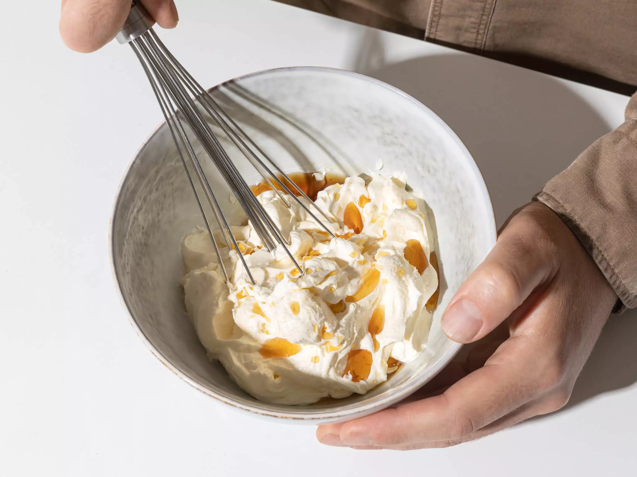 Butter, die mit einem Schneebesen geschlagen wird.