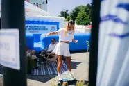 Frau balanciert auf Balanceboard bei der Kieler Woche 2025 vor blauen Inflatable-Strukturen.