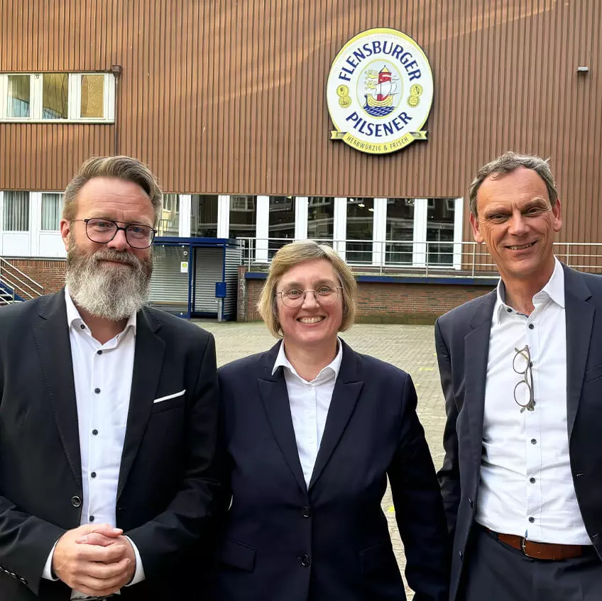 Claus Ruhe Madsen, Sylke Moerke und Jörn Schumann im Innenhof der Flensburger Brauerei.