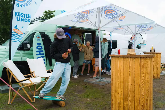 Ein Kind testet das Balance Board, das vor dem Küstenlimo-Promo-Van steht.