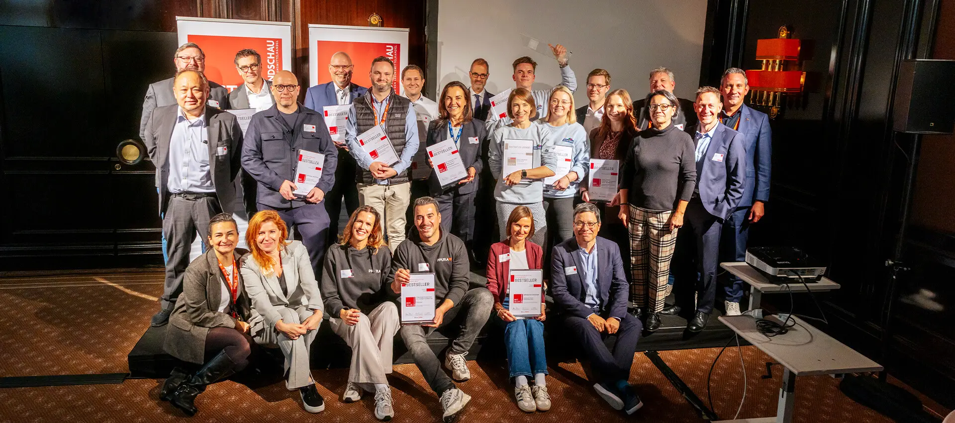 Gruppenfoto bei der Preisverleihung für den RUNDSCHAU Bestseller Award 2025 mit Zertifikaten auf Bühne.