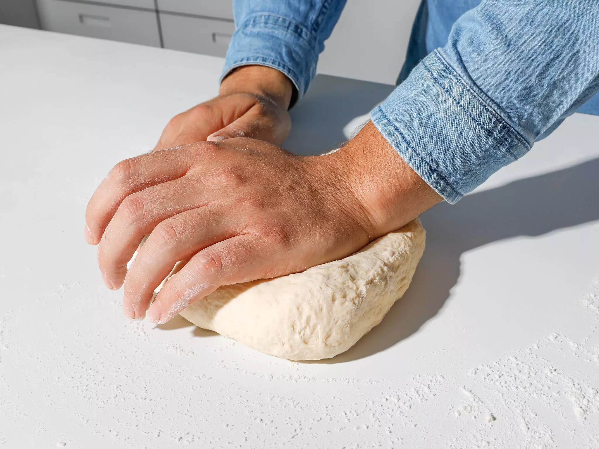 Pizzateig, der geknetet wird.