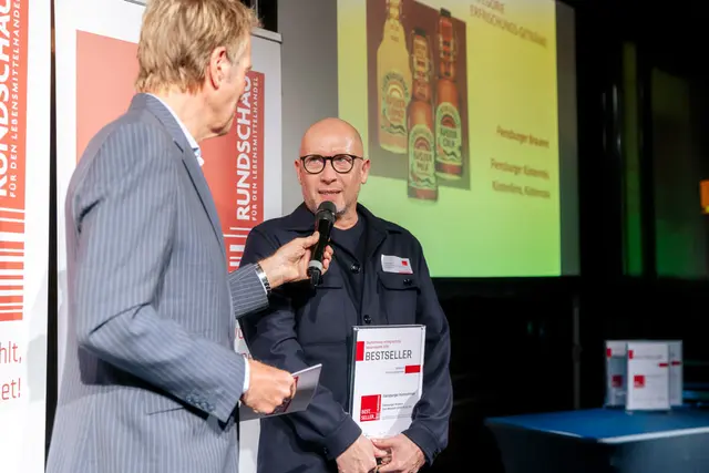 Moderator interviewt Preisträger bei Preisverleihung für den RUNDSCHAU Bestseller Award 2025.