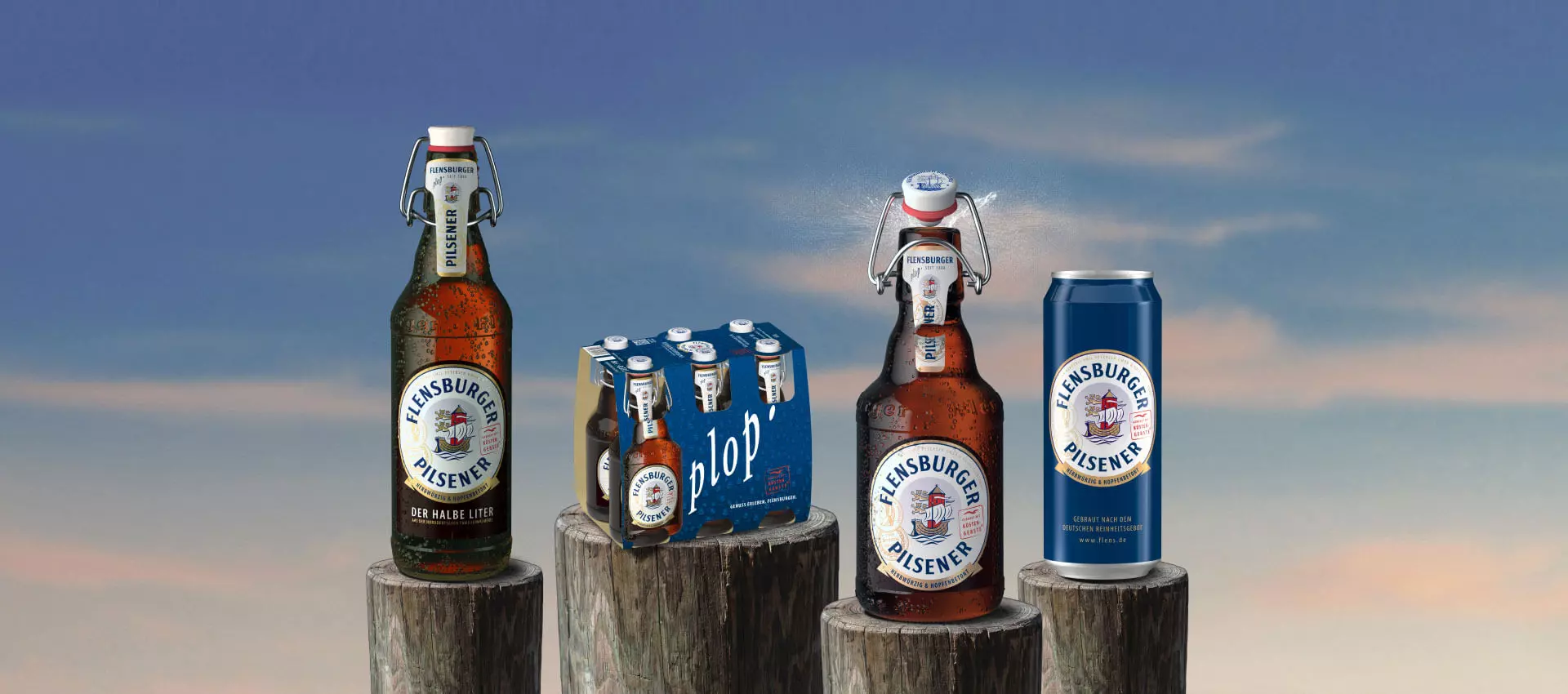 Vier Gebindeformen des Flensburger Pils stehen auf Holzstämmen in der Abenddämmerung.