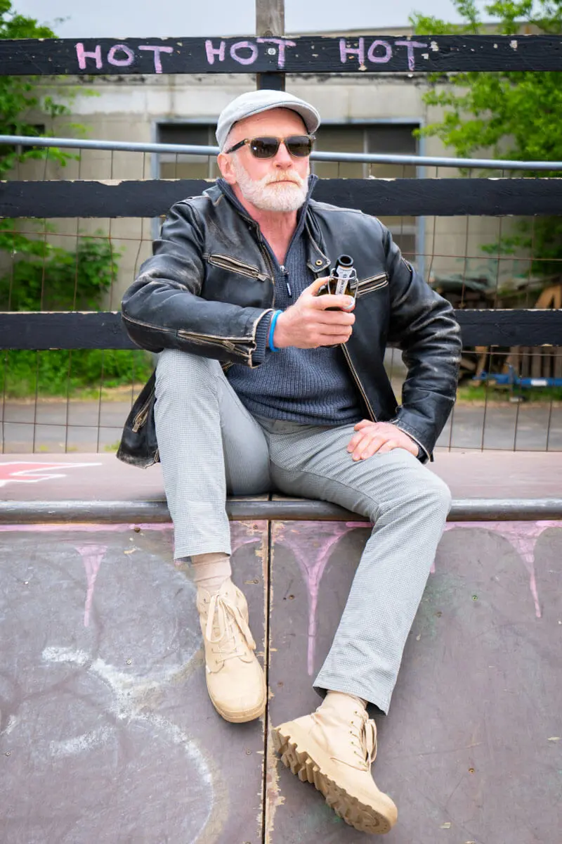 Andreas Arndt mit Lederjacke und Sonnenbrille auf Skate-Rampe, hält eine FLENS Flasche in der Hand, im Hintergrund gesprayt: "Hot hot hot".