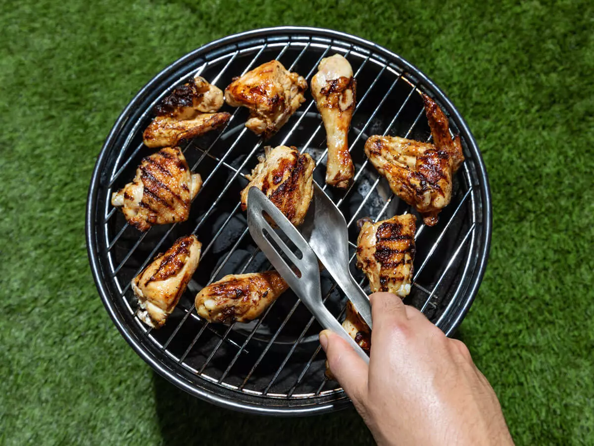 Hähnchen auf einem Grill, auf einer Wiese.