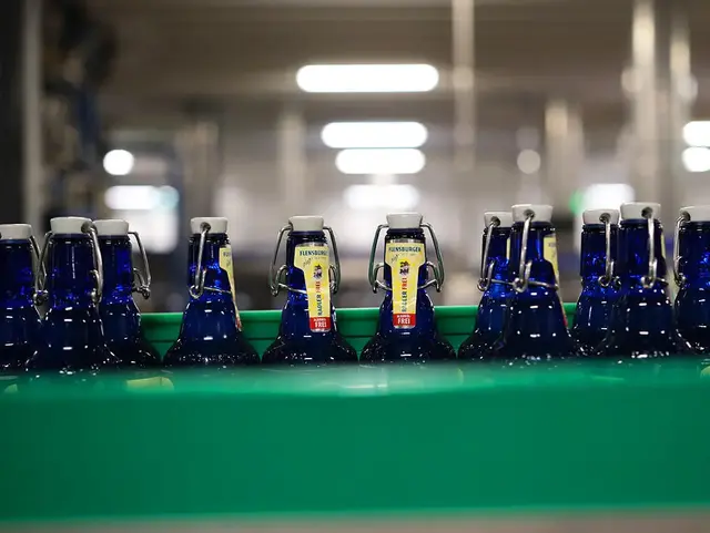 Blaue Bierflaschen, die mit Radler Frei befüllt werden, in der Abfülllinie.