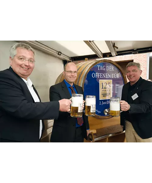 Drei Männer die mit Flensburger Krügen anstoßen.