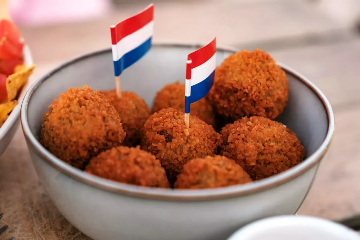 Niederländische Bitterballen in der Schüssel, zwei Zahnstocher-Fähnchen in den Landesfarben darauf.