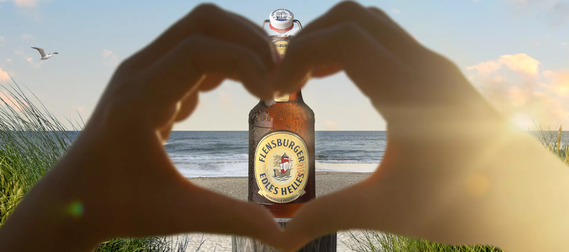 Zwei Hände formen ein Herzsymbol, in der Mitte des Herzen steht eine Flensburger Pilsener Flasche.