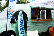 Der Küstenlimo-Promo-Van mit Surfbrett und Neoprenanzug.