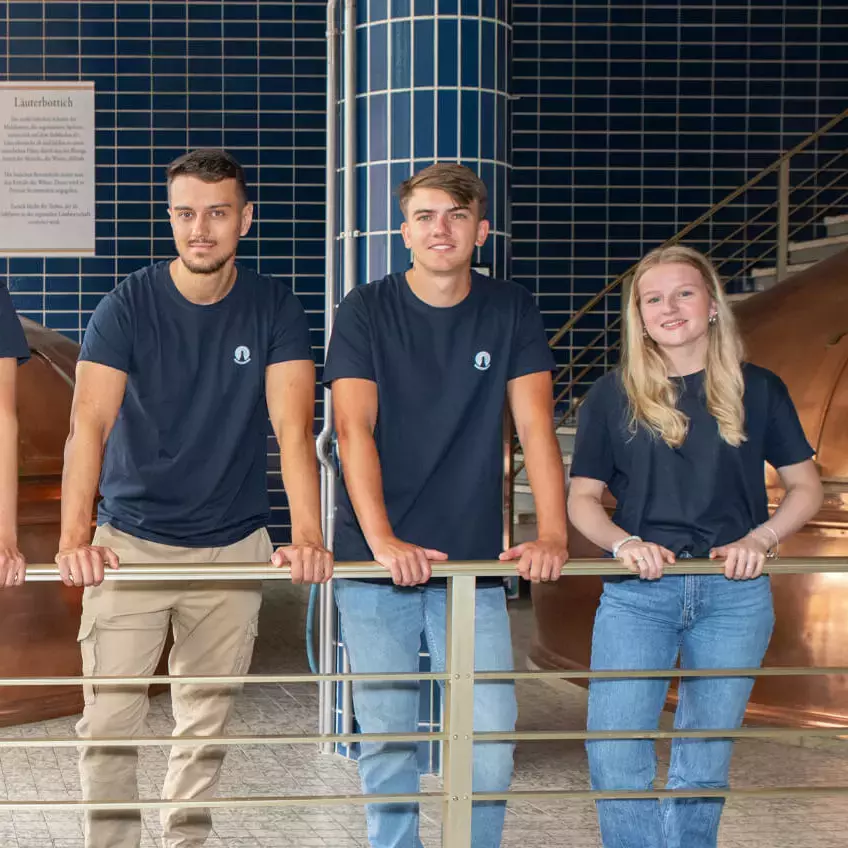 Die sechs neuen Azubis der Flensburger Brauerei aus 2024 im Sudhaus.