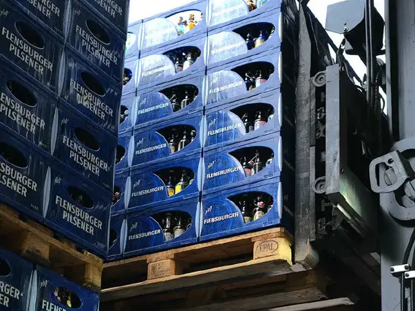 Palette mit den blauen Flensburger Kisten wird gestapelt.