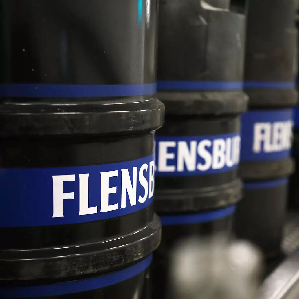 Schwarze FLENS Fässer in einer Reihe.