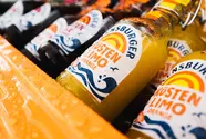 Die Flensburger Küstenlimo Orange in einer orangefarbenen Kühlbox.