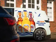 Der Küstenlimo-Bulli von der Seite: Die drei Küstenlimos auf mintfarbenem Hintergrund.