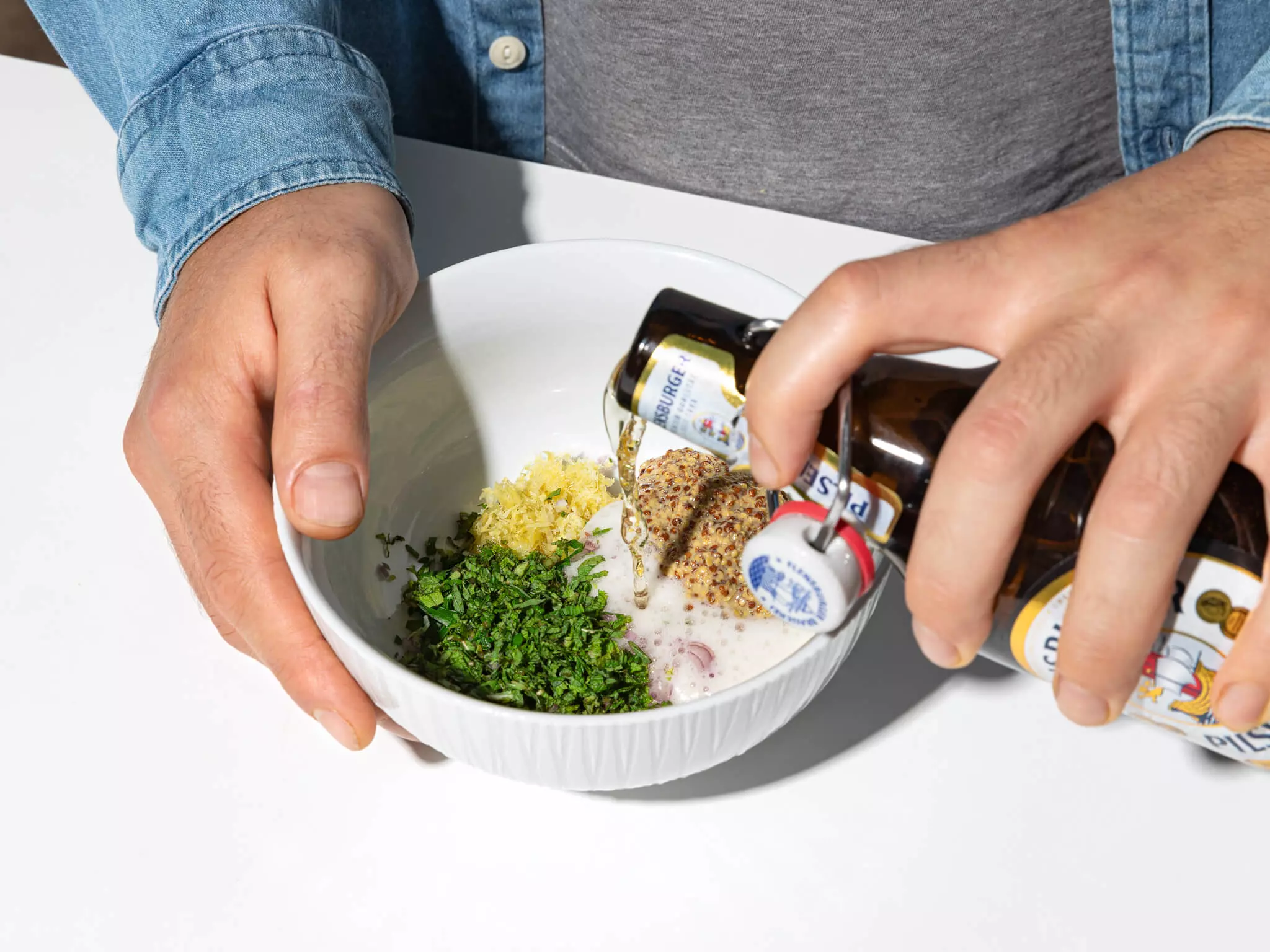 FLENS Pils, das in eine Schüssel mit Gemüse gegossen wird.