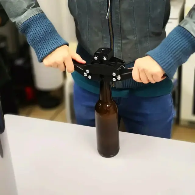 Manuelles Verkorken einer Bierflasche mit Kronkorken.