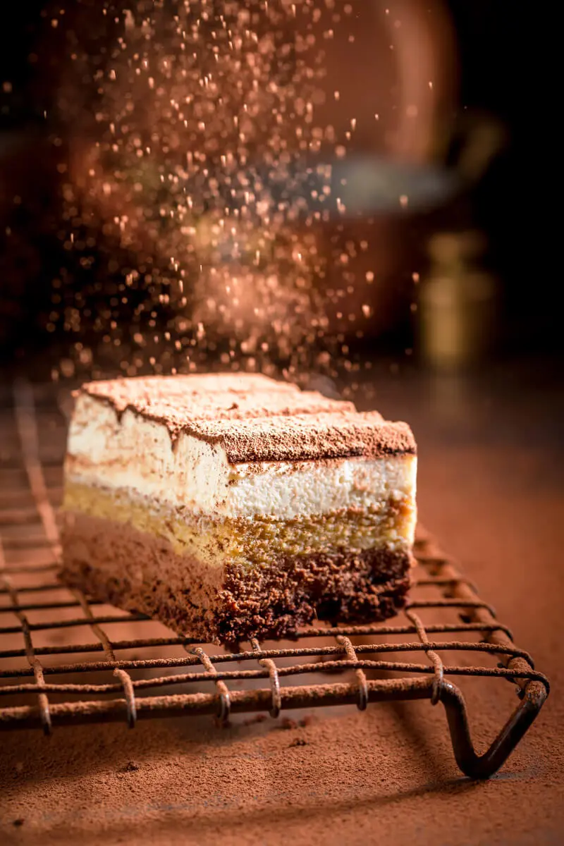 Stück Bieramisu (Tiramisu mit Bier) wird mit Kakaopulver bestäubt.