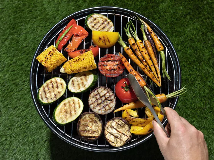 Gemüse, das auf einem Grill, auf einer Wiese steht.